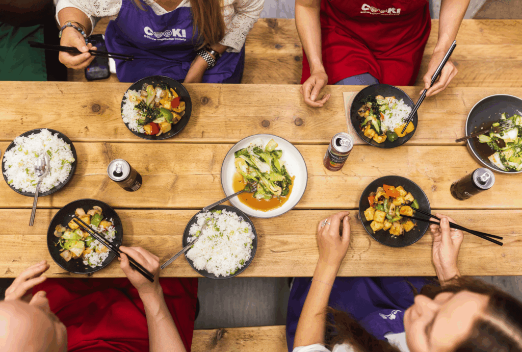 Class attendees sharing a meal around a table in COOK!